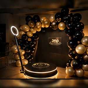360 photo booth setup with black and gold balloon backdrop and ring light